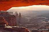 landscapes stock photography | Mesa Arch at Sunrise, Island in the Sky, Canyonlands National Park, Utah, USA, Image ID CANYONLANDS-NATIONAL-PARK-UTAH-USA-0008. Mesa Arch is the worlds most popular arch. It's located in the Island in the Sky District of Canyonlands National Park above Colorado River near Moab in Utah, USA. This image was made at sunrise when the first rays of light make the bottom of the arch glow orange.