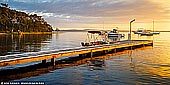 Wangi Point Jetty at Sunrise - Fine art print of Wangi Wangi, Lake Macquarie, NSW, Australia - Calm and peaceful image of a beautiful sunrise over the Lake Macquarie at Wangi Point Jetty in NSW, Australia. A typical but yet romantic scene along the shores of the Lake Macquarie, jetty with fishing boats at sunrise. The sunrises on the East coast of Australia, as the sun rises above the horizon an orange and yellow glow over the Pacific waters, lakes and beaches. - Image ID: AU-LAKE-MACQUARIE-0003