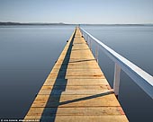 landscapes stock photography | Long Jetty, Tuggerah Lake, Central Coast, NSW, Australia, Image ID AU-NSW-LONG-JETTY-0001. Long Jetty is appropriately named as it features 3 extremely long jetties spanning out over the shallow waters of Tuggerah Lake: Parrys Jetty, Walkins Jetty and Long Jetty. The jetty was first built in 1915 and has become the namesake of the town of Long Jetty. The public artworks are a showcase of the history of the area - the pioneers who built the jetty and the local community, plus the many generations of visitors who spent time on and around Tuggerah Lake.