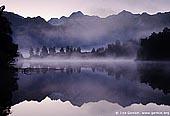 landscapes stock photography | Mt Tasman and Aoraki/Mt Cook reflected in Lake Matheson, Lake Matheson, South Westland, South Island, New Zealand, Image ID NZ-LAKE-MATHESON-0001. Sunrise light on the Southern Alps being perfectly reflected in the calm waters of Lake Matheson near Fox Glacier. At Lake Matheson nature has combined exactly the right ingredients to create truly stunning reflections of New Zealand's highest peaks - Aoraki (Mount Cook) and Mount Tasman. New Zealand's highest mountain, Mount Cook or Aoraki (3,754m) is on the right, and Mount Tasman (3,498m) is on the left.