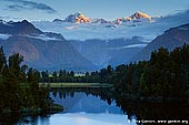 landscapes stock photography | Mt Tasman and Aoraki/Mt Cook at Sunset, Lake Matheson, South Westland, South Island, New Zealand, Image ID NZ-LAKE-MATHESON-0002. Sunset over two highest peaks in New Zealand - Mt. Cook (3,754m) and Mt. Tasman (3,497m) with their reflections in beautiful Lake Matheson near Fox Glacier township, situated in Westland National Park on West Coast of the South Island of New Zealand. Lake Matheson is a glacier lake which was formed about 14,000 years ago. The lake is surrounded by native kahikatea (white pine) and rimu (red pine) trees, as well as flax and a variety of New Zealand fern species.