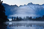 landscapes stock photography | Dawn at Lake Matheson, Lake Matheson, South Westland, South Island, New Zealand, Image ID NZ-LAKE-MATHESON-0005. Early morning mist over Lake Matheson near Fox Glacier township, located in Westland National Park on West Coast of the South Island of New Zealand and the second highest peak in New Zealand - Mt. Tasman (3,497m) as the backdrop. Lake Matheson is one of the most photographed lakes on the west coast.