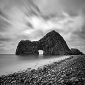 portfolio stock photography | Senganmon at Kumomi, Izu Peninsula, Shizuoka Prefecture, Japan, Image ID JAPAN-KUMOMI-SENGANMON-0002. Senganmon is a sea erosional cave at the edge of Kumomi, to the south of Matsuzaki Town on Izu Peninsula, Shizuoka Prefecture, Japan. The site has a 30-meter-high rock wall with a tunnel (height of 10m; width of 15m) shaped like a gate, which was originally named as Sengenmon after the gate at Sengen Shrine. Many years ago, the name changed to Senganmon implying that the beautiful unusual view is as valuable as a thousand piles of money (sengan-mon).