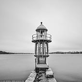 portfolio stock photography | Robertson's Point Lighthouse, Cremorne, Sydney, NSW, Australia, Image ID SYDNEY-IN-SQUARE-0010. Robertson Point Light, also known as Cremorne Point Light, is an active lighthouse in Cremorne Point, a suburb on the lower North Shore of Sydney, New South Wales, Australia. At the very tip, visitors can wander down some old steps to the lighthouse, and the more adventurous can continue down a rather precarious ladder to the water's edge. The spectacular harbour views can be enjoyed from a number of bench seats. A memorial plaque reminds visitors to take extra care and respect the inherent dangers of the rocky coast. Built 1909 this light is of the same form and construction as the Bradley's Head lighthouse which was the first of this design to be erected. The Robertsons Point Lighthouse is of State significance as an integral component of the navigational system which ensures the safe operation of the Port of Sydney. It is an important harbour navigation light which is a minor landmark on the tip of Roberston Point. It is one of the early examples of the use of re-enforced concrete in maritime situations and uses both in-situ and pre-cast sections.