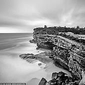 portfolio stock photography | The Gap, Watsons Bay, Sydney, NSW, Australia, Image ID SYDNEY-IN-SQUARE-0019. The Gap is one of Sydney's most famous lookout points. From the top of near-vertical ocean cliffs, you look out at breathtaking views across the Tasman Sea. Below you, the waves pound a sandstone plateau and, depending on the weather, you can see spectacular displays as the foamy waves crash in and shoot upwards. The area is one of Sydney's most popular tourist destinations. It attracts international and national tour groups, independent visitors, and local residents who use the park for walking, harbour and ocean viewing, bird watching, whale watching and spectating major harbour events. Additionally the park supports a rich history containing early fortifications, shipwreck relics, and disused gun placements from past wars.