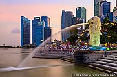singapore stock photography | The Merlion at Sunset, Marina Bay, Singapore, Image ID SINGAPORE-0002. The Merlion statue and city skyline of Central Financial District along Singapore River at sunset. The Merlion is the mythical creature with the head of a lion and the body of a fish. The body symbolises Singapore's humble beginnings as a fishing village when it was called Temasek, meaning 'sea town' in Old Javanese. Its head represents Singapore's original name, Singapura, or 'lion city' in Malay.