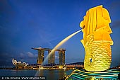 singapore stock photography | The Merlion and Marina Bay Sands Hotel at Sunset, Marina Bay, Singapore, Image ID SINGAPORE-0005. Merlion Park houses a Singapore icon that is half-fish and half-lion, and famous throughout the world. The body symbolises Singapore's humble beginnings as a fishing village when it was called Temasek, meaning 'sea town' in Old Javanese. Its head represents Singapore's original name, Singapura, or 'lion city' in Malay. Today, you can glimpse this legend at Merlion Park. Spouting water from its mouth, the Merlion statue stands tall at 8.6 metres and weighs 70 tonnes. This icon is a 'must-see' for tourists visiting Singapore, similar to other significant landmarks around the world. Built by local craftsman Lim Nang Seng, it was unveiled on 15 September 1972 by then Prime Minister Lee Kuan Yew at the mouth of the Singapore River, to welcome all visitors to Singapore.