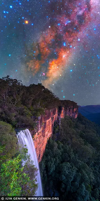  stock photography | Milky Way Rising Above Fitzroy Falls, Morton National Park, NSW, Australia. Here, Fitzroy Falls takes on an entirely different presence. The white ribbon of water drops into darkness below, while the cliff face holds the last trace of earth and texture beneath a sky filled with stars. Above it all, the Milky Way rises in rich bands of light and colour, giving the scene a sense of quiet wonder that feels both vast and deeply still. This is a landscape that speaks to solitude, scale and perspective. The contrast between the grounded weight of the escarpment and the immense sweep of the night sky creates a feeling of calm awe - the kind of moment that pulls you out of daily noise and into something slower, wider and more enduring. It is less about spectacle and more about presence. As wall art, this image brings depth, atmosphere and a strong sense of place into a room. The dark forest tones, warm rock and luminous sky give it a balanced visual weight that suits a living space, office or studio, where it can offer both focus and escape. Offered as a fine art wall art print, made to be lived with and revisited over time. Created to live on your wall, not just on a screen.