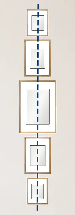 Vertical arrangement of framed pictures aligned along a central plumb line on a narrow wall.